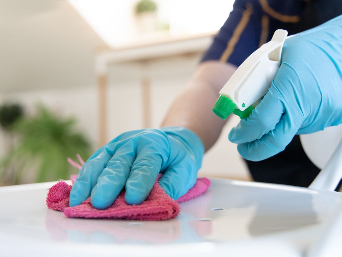 a person cleaning a surface with a pink cloth