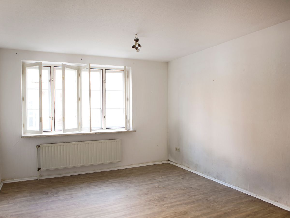 a room with a wood floor and windows